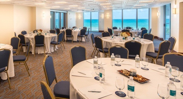 Meeting room with tables and settings with an ocean view.