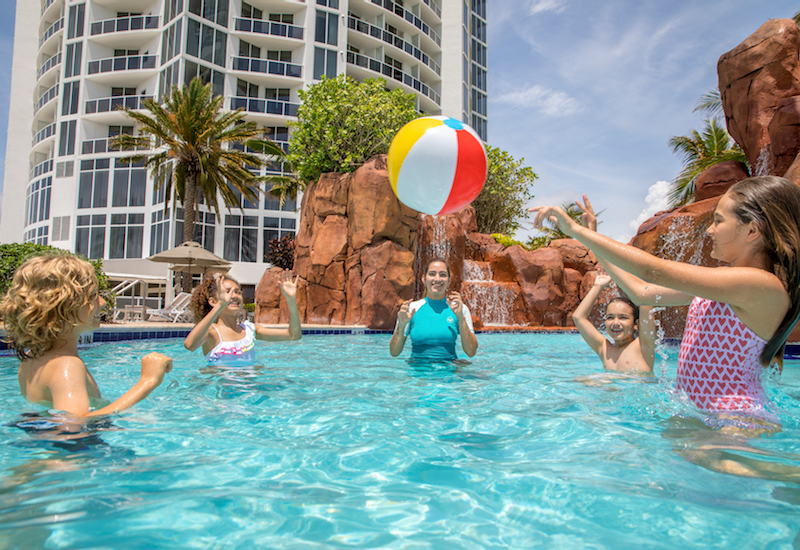 Kids playing with a beach ball in the pool at Trump International Beach Resort