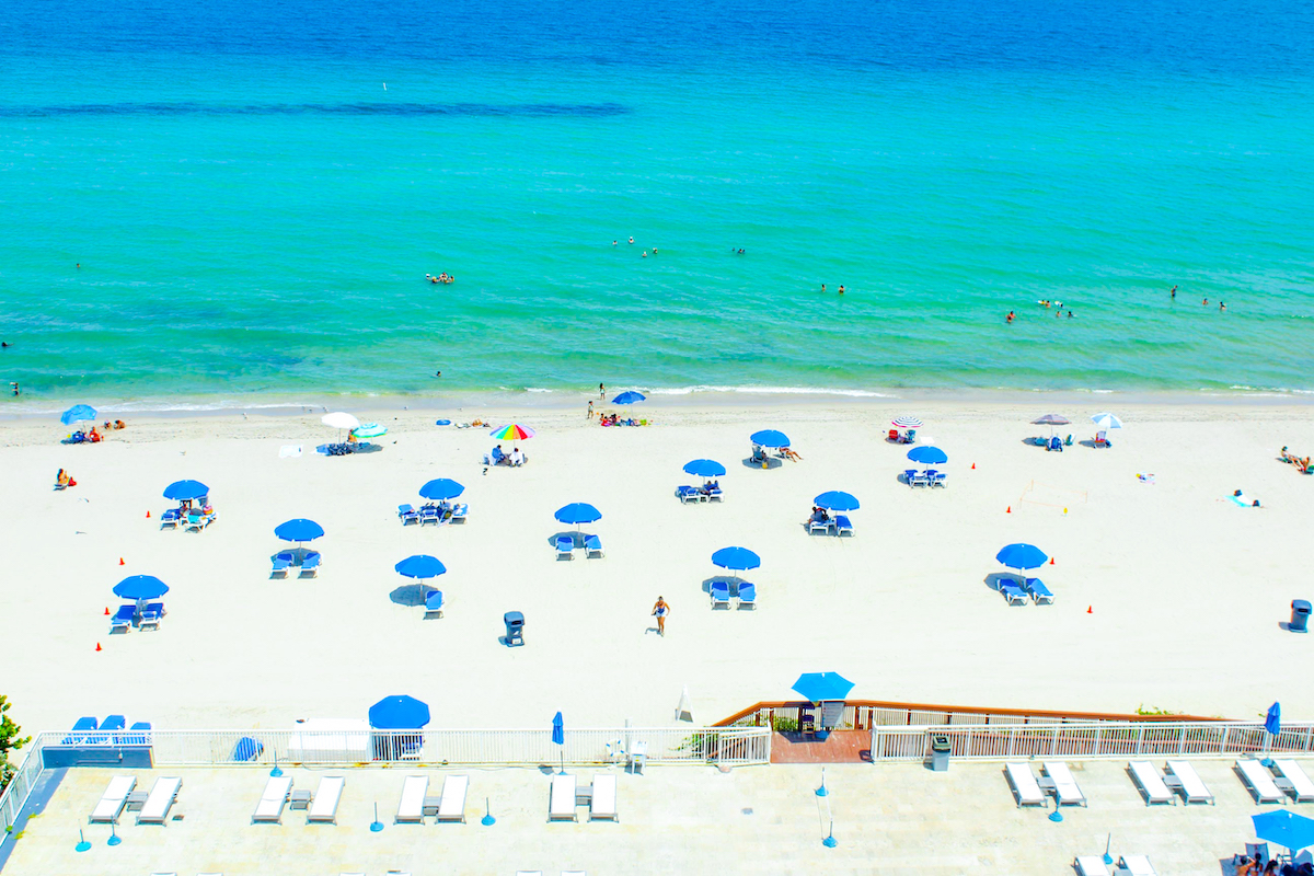 Blue umbrellas on the white sand beach.