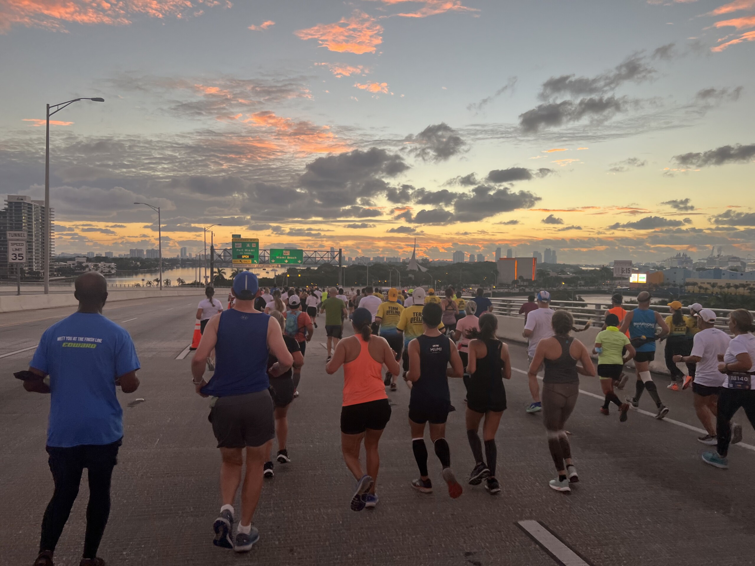 Runners running toward the sunrise on MacArthur Causeway