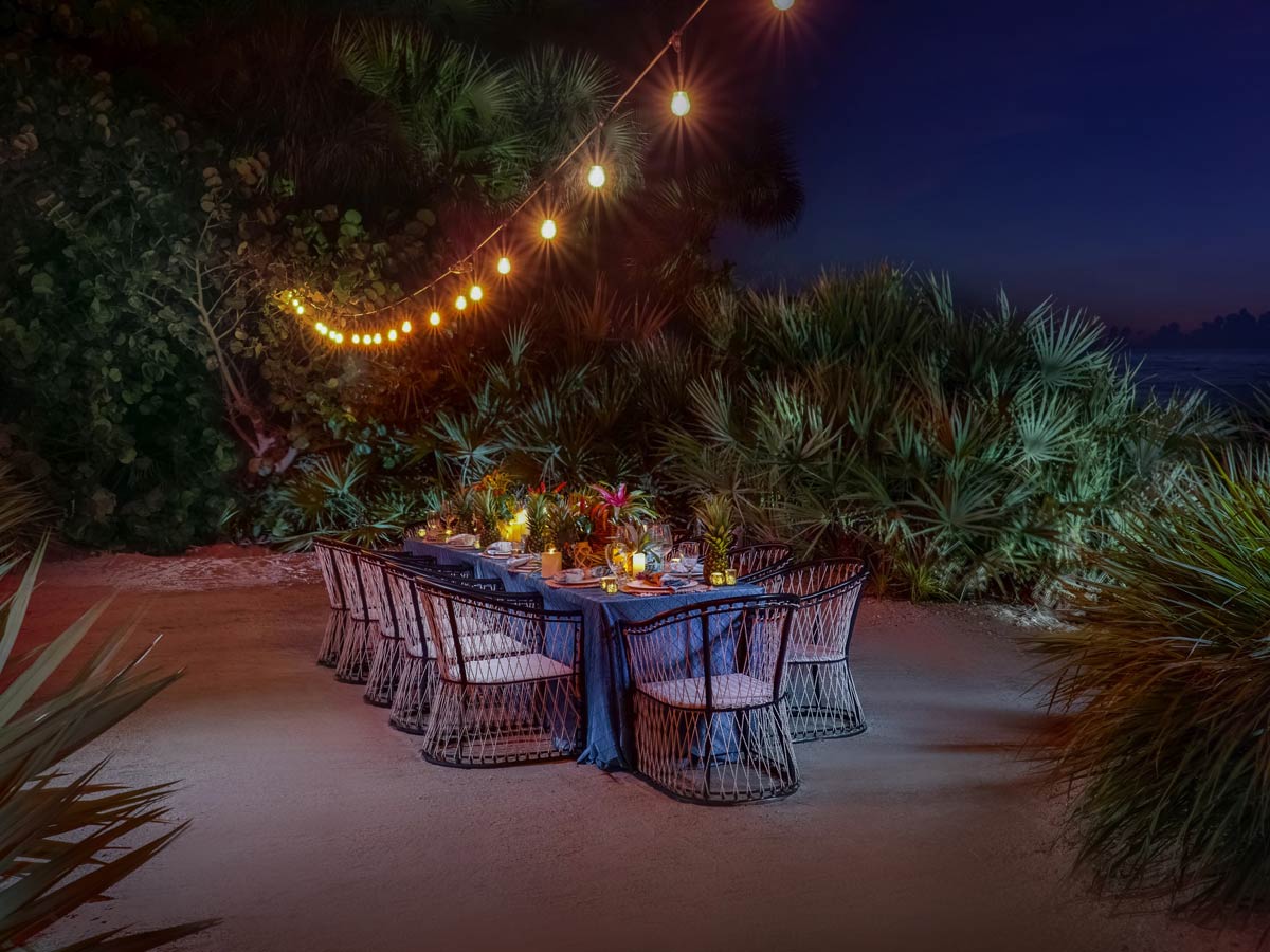 a table decorated for a special event outside the property on the beach